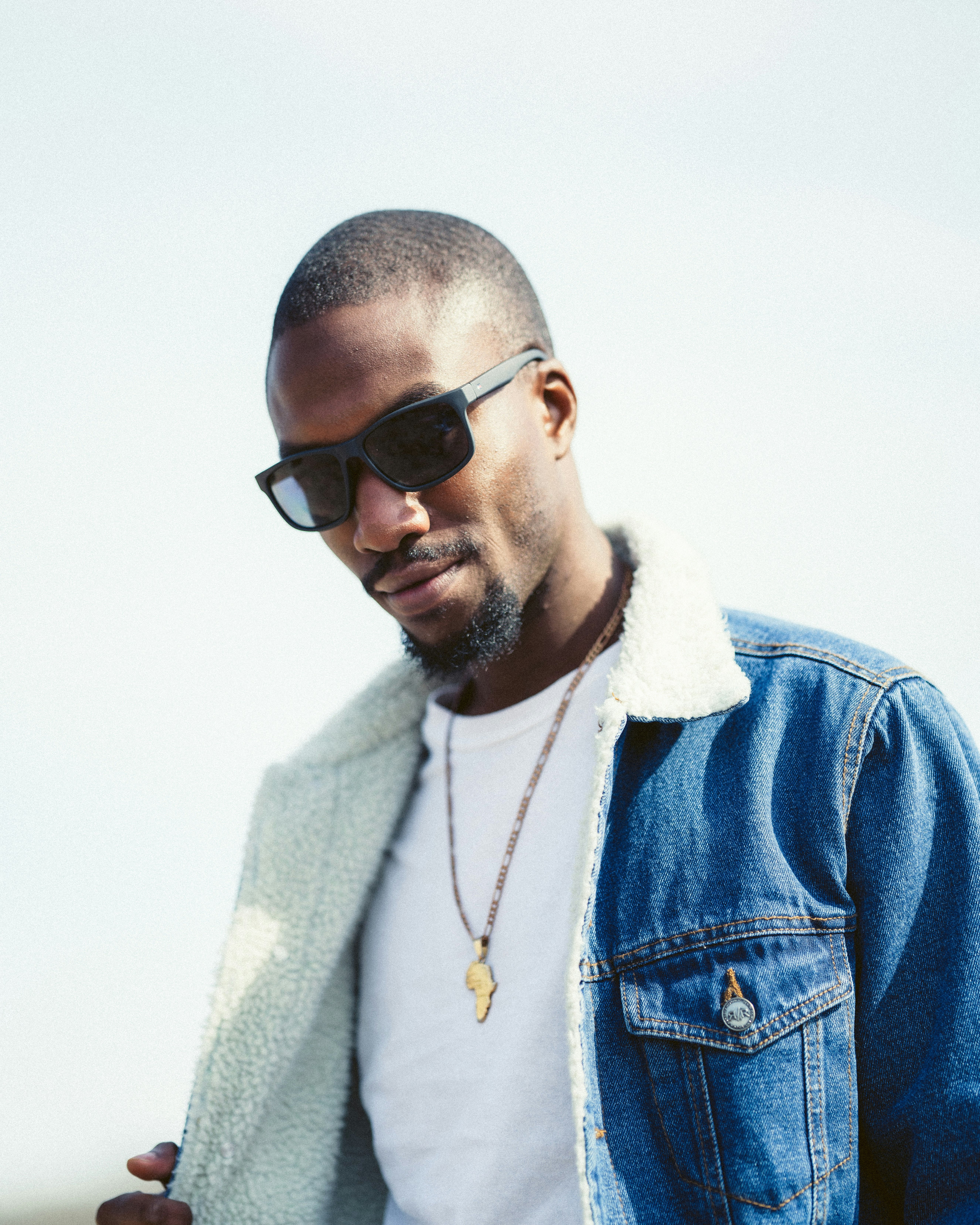 man in blue denim jacket wearing black sunglasses